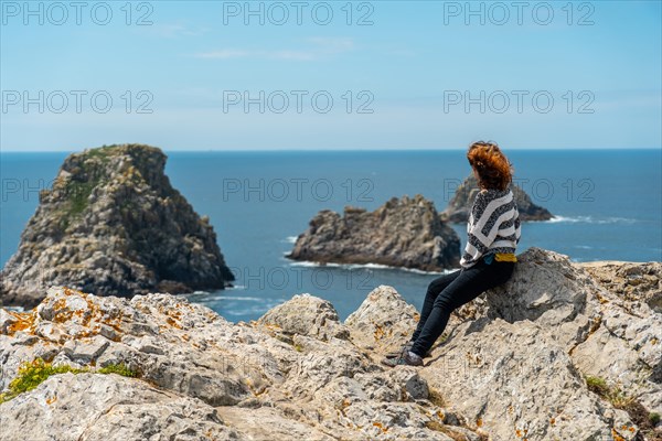 A young tourist girl looking at the sea at Pen Hir Point on the Crozon Peninsula in French Brittany