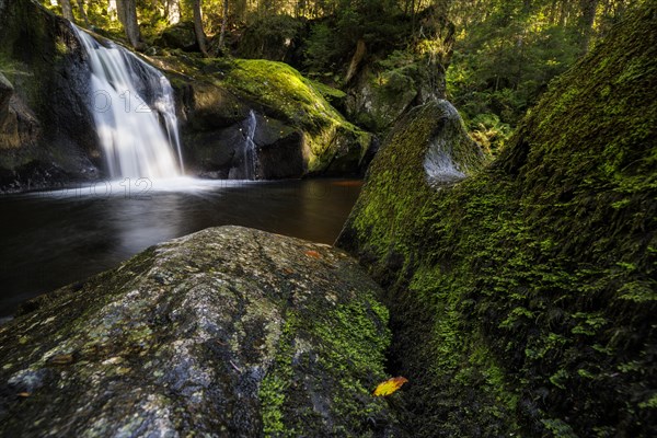 Waterfall in autumn forest with rocks