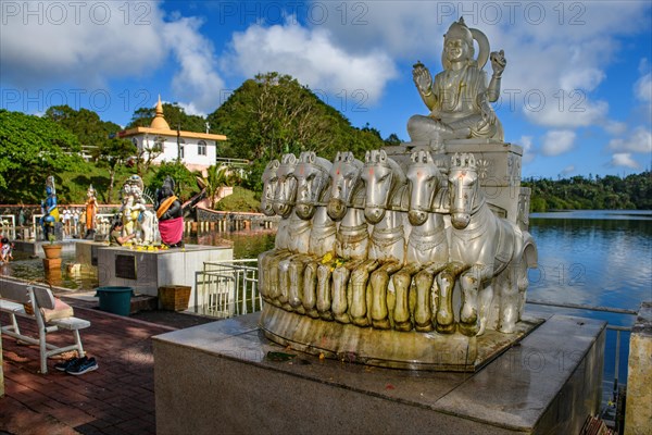 God deity Surya with seven horses personification of sun heat light at religious site largest Hindu sanctuary sanctuary for religion Hinduism outside of India for devout Hindu Hindus in background Sac...