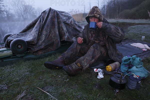Man drinking a coffee in nature at sub-zero temperatures