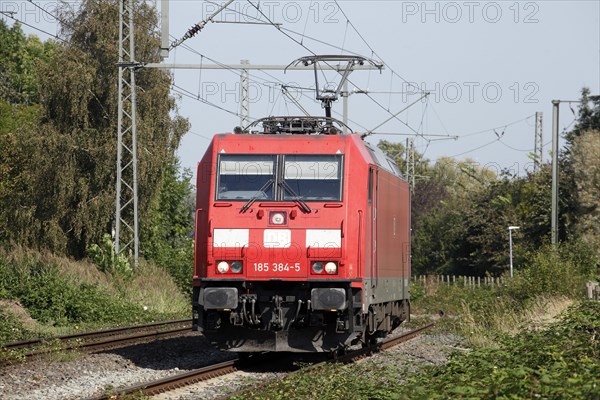 Red locomotive class 185 on a railway track