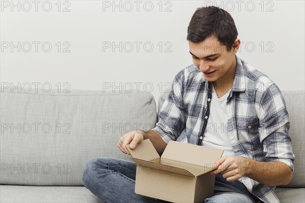High angle man couch opening box