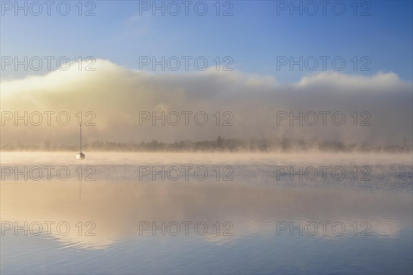 Fog over Lake Constance on an autumn morning with boats