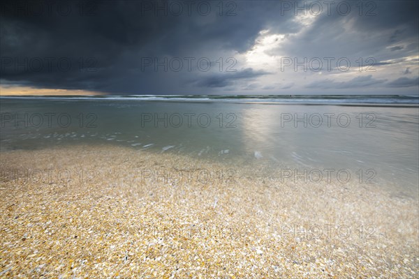 Evening mood with cloudy sky and rain on the beach and in the dunes of De Panne