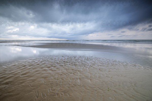Evening mood with cloudy sky and rain on the beach and in the dunes of De Panne
