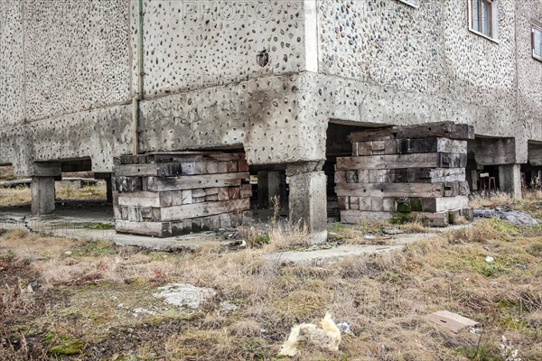 Pallets support a residential building that is in danger of sinking due to the thawing permafrost