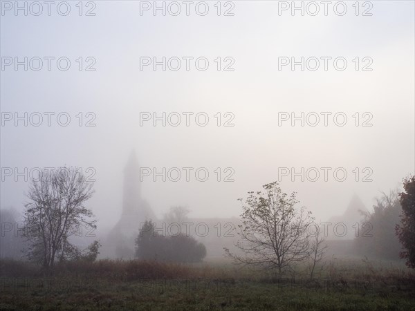 Church tower in the morning mist