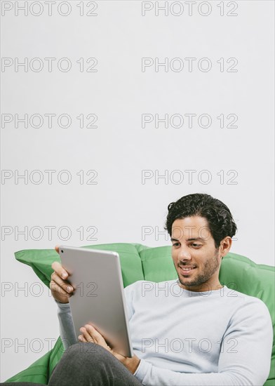 Smiley man having fun with tablet