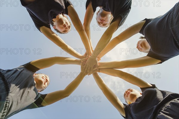 Young women putting hands together