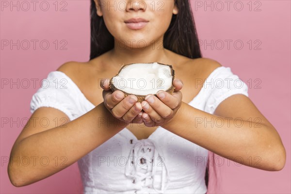 Half coconut being held by woman