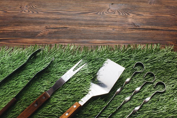 High angle view barbecue utensil set green mat wooden table