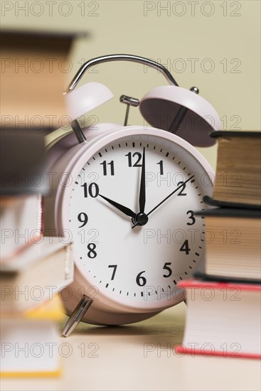 Close up alarm clock stacked books