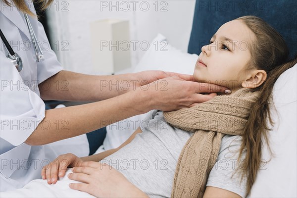 Close up female s doctor hand checking girl patient s throat neck