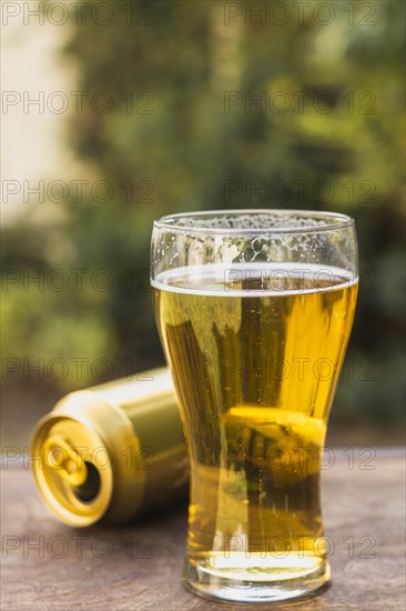 Glass with beer beside beer can