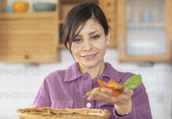 Woman in the kitchen disposes of organic waste in basket Environmental protection
