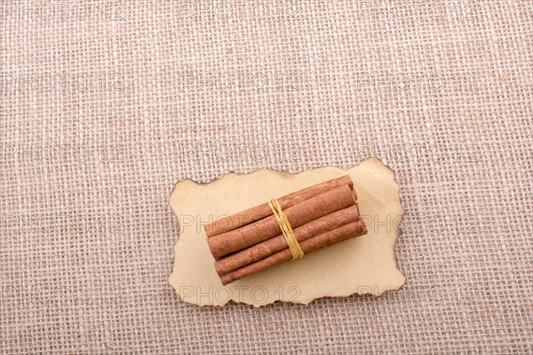 Bundle of cinnamon sticks on a linen canvas background