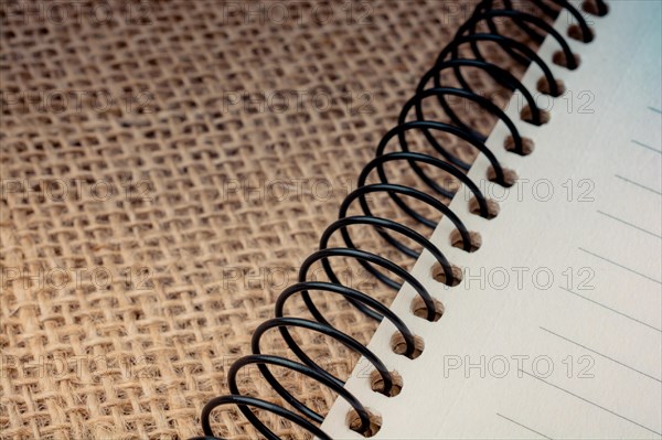 Brown color spiral notebook placed on a canvas background