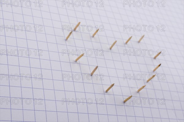 Nails make hole on paper forming a heart shape