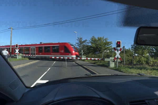 View from a car of the passing railway at a level crossing with barriers