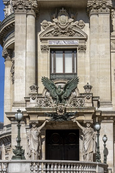 The opulent entrance to the Palais Garnier opera house with caryatids and a large eagle sculpture above the door
