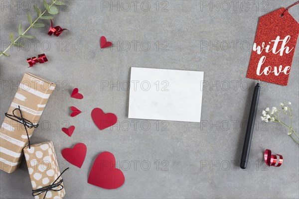 Present boxes near paper hearts sheet pen tag