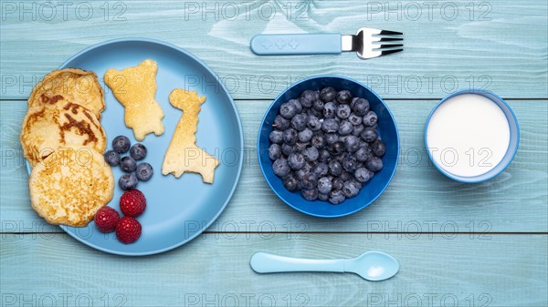 Top view blueberries with baby food cutlery