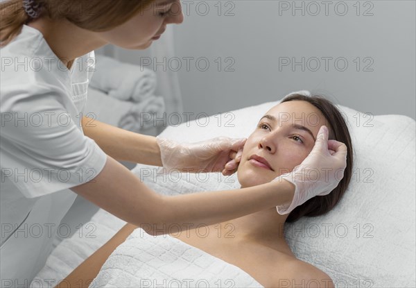 Beautician with female client salon face care routine 3