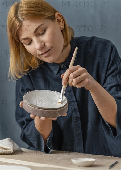 Medium shot woman painting vase