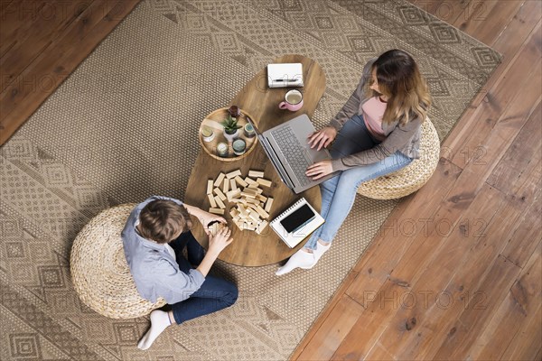 Top view mother working from home her son