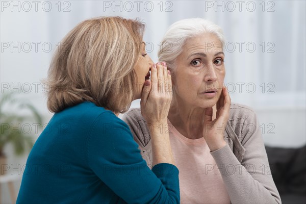 Portrait mature women whispering
