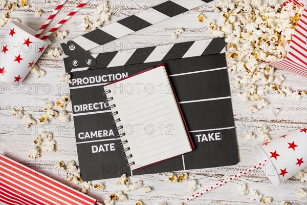 Spiral notepad clapperboard drinking straw popcorns wooden desk
