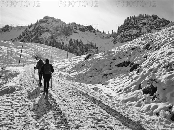 Two female hikers climbing up to the Bodenschneidhaus in winter