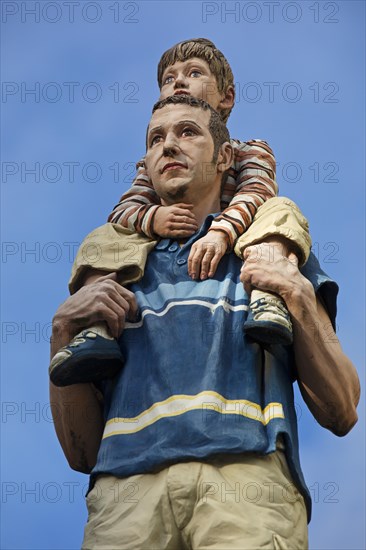 Realistic sculpture of a pillar saint father and son on a lift barrel pillar