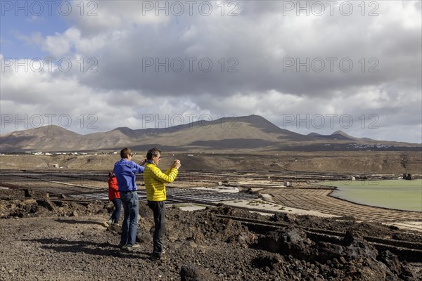 Tourists photographing the Janubio salt flats