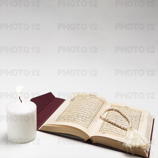 Front view holy book with lit candle