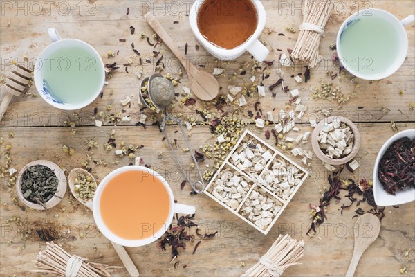 Different types tea ceramic cup with herbs honey dipper