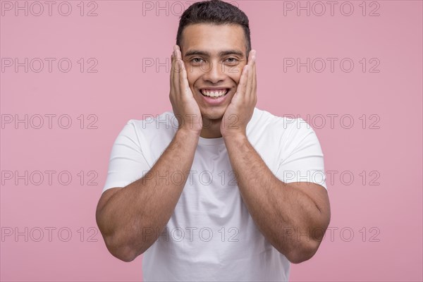 Front view smiley handsome man posing with palms his face