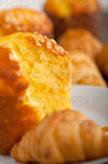 Fresh baked muffin and croissant mignon on old wood table