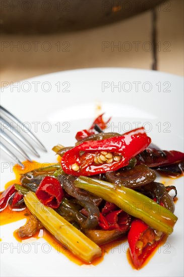Fried chili pepper and vegetable on a iron wok pan