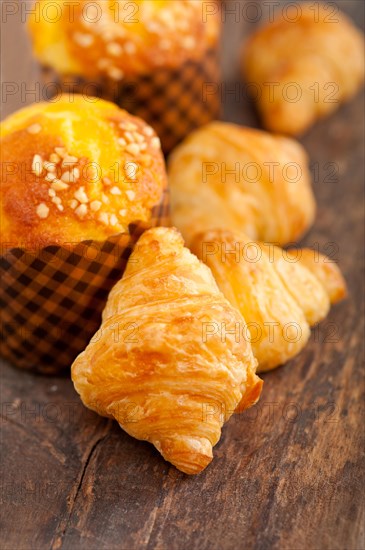 Fresh baked muffin and croissant mignon on old wood table