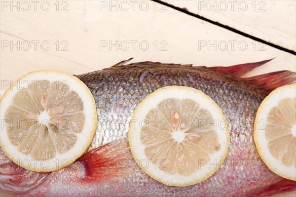 Fresh whole raw fish on a wooden table ready to cook