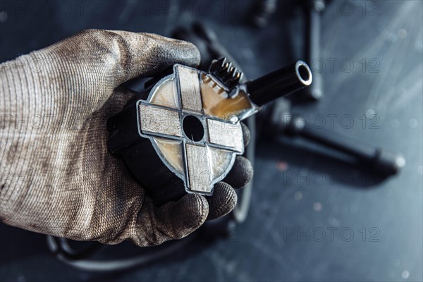 Engine ignition coil in hand of auto mechanic