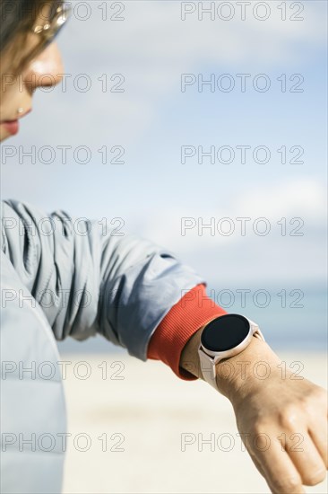 Close-up view of latina woman looking at smart watch