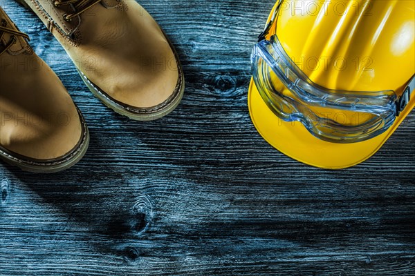 Safety glasses boots hard hat on wooden board