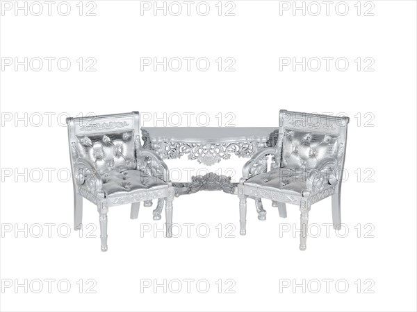 Two silver leather upholstery chairs with silver table on middle