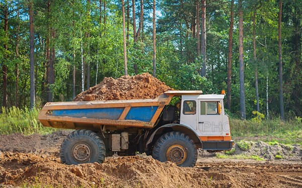 Large old tipper with clay floor in the forest
