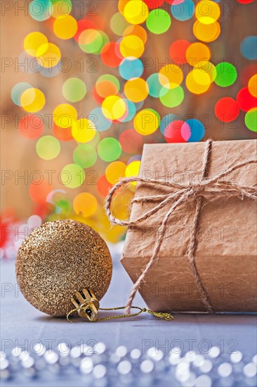 Close up view of vintage paper gift box and gold-coloured Christmas bauble on the table