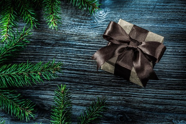 Brown present box pine branches on wooden board