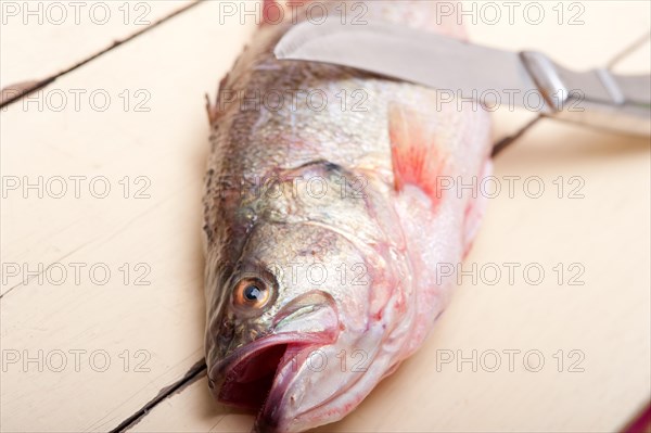 Fresh whole raw fish on a wooden table ready to cook