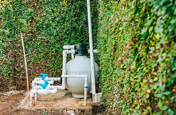 Home swimming pool filter and treatment plant installed. Pool pump with sand filter installed. Pool purification and maintenance system
